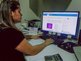 Em seu escritório, Edenise Gomes de Souza consulta site da Receita Federal. (Foto: Anahi Gurgel). 