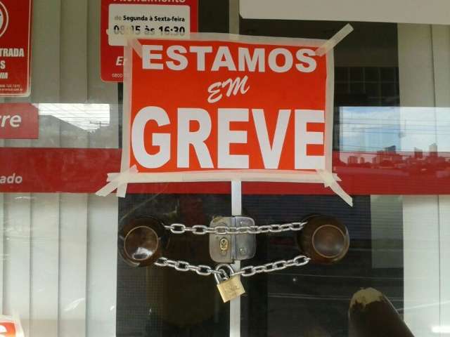 Em protesto para evitar demiss&otilde;es, grevistas fecham Enersul a cadeado 