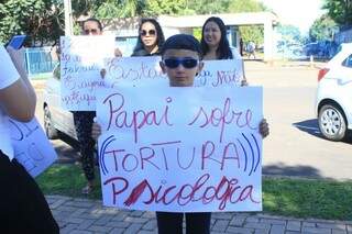 Filho de preso segurando cartaz em protesto que ocorreu na semana passada (Foto: Marina Pacheco)