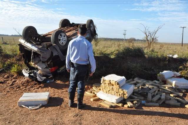 Traficante foge da pol&iacute;cia, mas capota carro e espalha maconha na estrada
