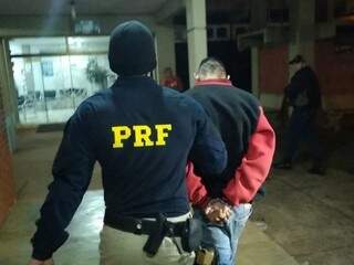 Gabriel Costa dos Santos, o “Degolado”, é conduzido por policial após ser preso na BR-463 com Amarok levada da casa de empresário (Foto: Adilson Domingos)