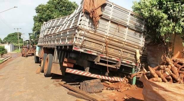 Asfalto cede e caminh&atilde;o carregado com mandioca afunda em rua