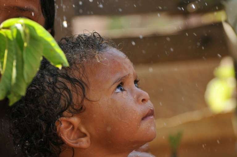 Água vira "benção" para criança no forte calor(Foto: Alcides Neto)