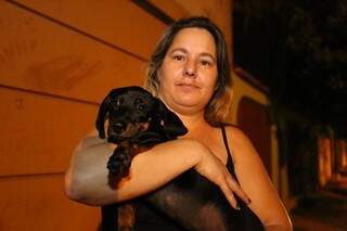 A representante comercial Célia segura o cachorro de sua amiga, vizinha a sua residência. (Foto: Marcelo Vitor)