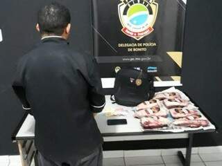 Chefe de cozinha em delegacia de Bonito ao lado de peças de picanha apreendidas (Foto: Divulgação)