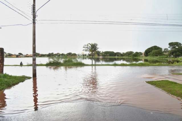 Problema recorrente, chuva faz Lagoa Itatiaia transbordar e inunda rua