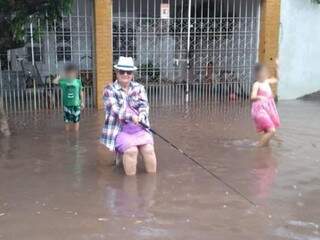 Em Corumbá, mulher encenou pescaria ao lado de crianças após chuvarada em novembro (Foto: Arquivo/ Diário Corumbaense)
