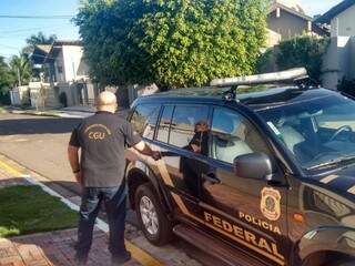 Servidor da CGU entra em viatura da Polícia Federal em frente a uma residência em Campo Grande (Foto: Divulgação)