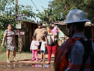 Família observa trabalho da concessionária de energia em área invadida (Foto: Henrique Kawaminami/Arquivo)
