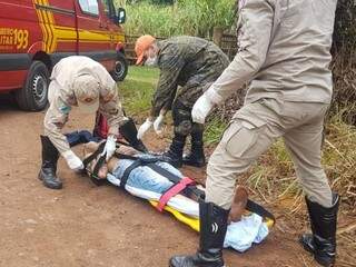 Corpo de Bombeiros socorrendo a vítima que foi encontrada ferida com tiro na cabeça (Foto: Mirian Machado) 