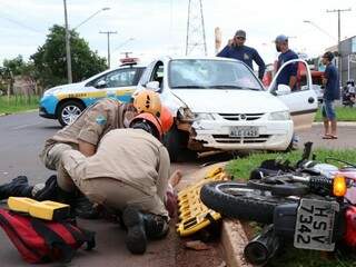 Bombeiros durante atendimento à vítima de acidente entre carro e moto (Foto: Henrique Kawaminami) 