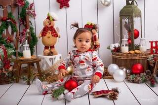 Criança brinca com a bolinha da árvore de Natal enquanto é fotografada (Foto: Hemily da Silva)