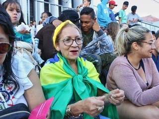 Eliane com a bandeira do Brasil acompanha início de desfile. (Foto: Henrique Kawaminami).