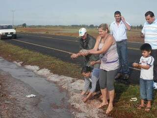 Moradores brincam com camada de gelo que se formou às margens de rodovia estadual (Foto: Divulgação)