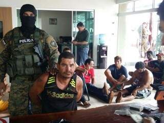 Policial paraguaio faz pose para foto ao lado de bandidos brasileiros presos após troca de tiros (Foto: Divulgação/Senad)