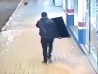 V&iacute;deo mostra ladr&atilde;o que arromba porta e sai tranquilamente pela rua com TVs
