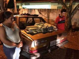 Casal preso na fronteira ao lado do carro com os tabletes de maconha (Foto: Divulgação)