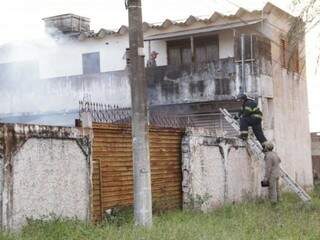 Militares precisaram pular o muro para combater o incêndio (Foto: Kisie Ainoã)