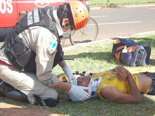 Bombeiro presta atendimento a vítima, que sofreu corte profundo na cabeça. (Foto: Marlon Ganassin)