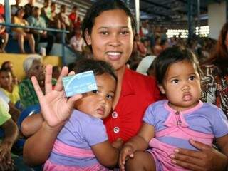 Mãe de gêmeas beneficiária do Vale Renda mostra cartão para sacar benefício durante mutirão de cadastramento (Foto: Governo de Mato Grosso do Sul/Divulgação/Arquivo)