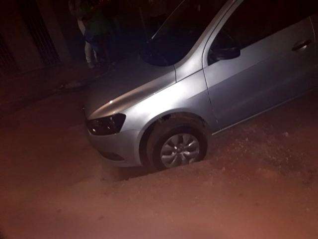 Carro fica preso em buraco no meio de rua no Jardim das Hort&ecirc;ncias