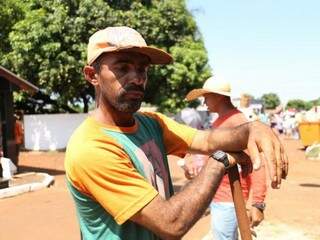 Jair Domingos cobra R$ 5,00 para limpar e carpir túmulos (Foto: Paulo Francis)