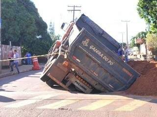 Caminhão ficou com rodas dentro do buraco na Rua Joanesburgo (Foto: Alcides Neto)