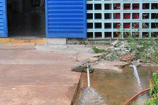Água sai em grandes quantidades de duas mangueiras deixadas no local. (Foto: João Garrigó)