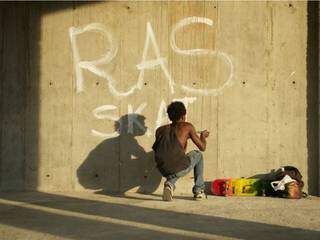 O protagonista pixa o nome dele no muro (Foto: Divulgação)