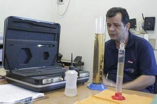Fernando mostra a diferença do combustível misturado com a água (Foto: Marcos Ermínio)