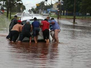 Testemunhas ajudaram na retirada do veículo do buraco (Foto: Alcides Neto)