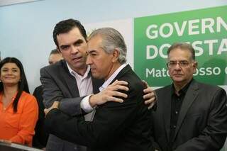 Carlos Alberto Coimbra recebe o abraço do governador Reinaldo Azambuja, observado pelo ex-secretário de Saúde, Nelson Tavares, durante sua posse nesta quarta-feira (Foto: Marcos Ermínio)