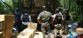 Policiais entre caixas de contrabando, na zona rural de Caracol.