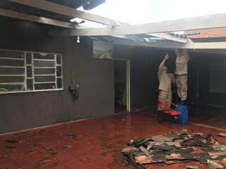 Bombeiros averiguam estrago em telhado causado após ventania. (Foto: Ronie Cruz).