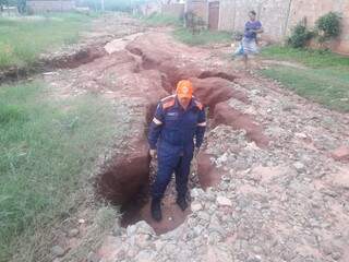Integrante da Defesa Civil dentro de um dos buracos (Foto:Direto das Ruas)