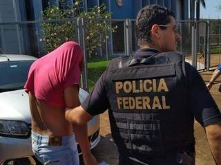 Um dos presos na Operação Nepsis esconde o rosto ao chegar à delegacia da PF em Dourados (Foto: Adilson Domingos)