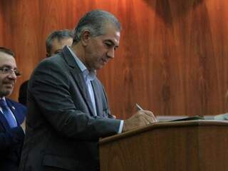 Governador do Estado, Reinaldo Azambuja, assina documento durante solenidade na OAB. (Foto: Marina Pacheco/Arquivo).