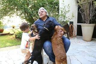 Antônio, o caçulinha da casa, no abraço aos cães. Amor passado de pai para filho. (Foto: Fernando Antunes)