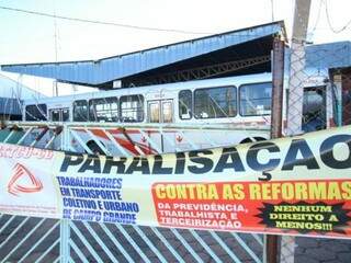 Na Viação Cidade Morena, ônibus parados e placa de paralisação. (Foto: André Bittar)