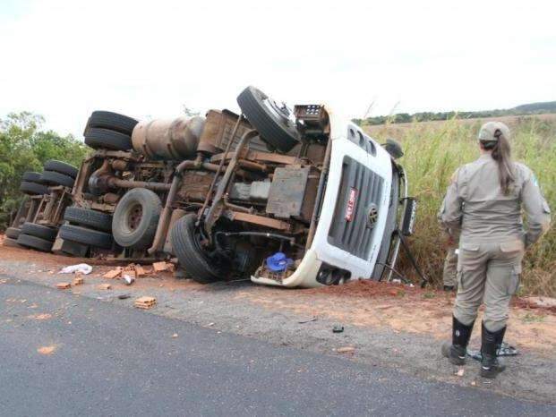 Motorista fica ferido ap&oacute;s caminh&atilde;o com tijolos tombar em curva