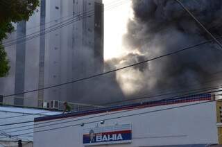 Homem estava sobre o telhado da loja e bombeiros suspeitam dele (Foto: Vanderlei Aparecido)