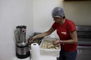 Funcionária trabalha na preparação dos salgados da Coxinha Express.