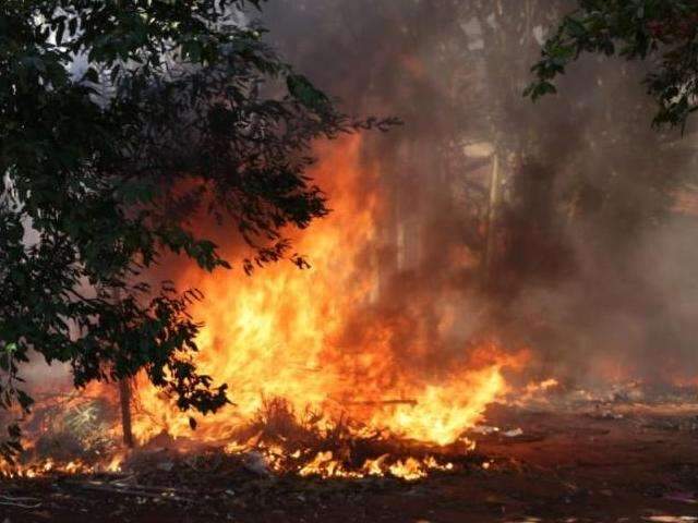 Fogo em terreno assusta e moradores tentam conter chamas jogando terra 
