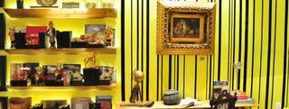 Na parede da Sala da Lareira, a fita preta em veludo produz o efeito papel de parede sobre a tinta amarela viva.