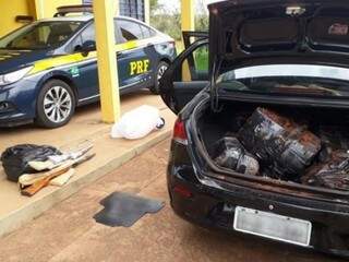 Sacos com maconha em porta malas de carro e armas apreendidas (Foto: Divulgação/ PRF)