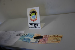 Dinheiro que vítima havia depositado para golpista, que tem extensa ficha criminal e usava três celulares. (Foto: Pedro Peralta)