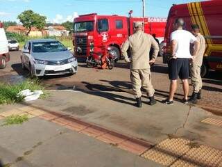 Carro envolvido em acidento ao lado de Biz vermelha e militares dos bombeiros (Foto: Direto das Ruas)