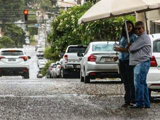 Os prevenidos já abriram o guarda chuva na manhã desta quinta-feira (28) em Campo Grande (Foto: Marcos Maluf)