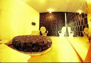 Detalhes de um dos quartos do hotel com cama redonda e parede espelhada. (Foto: Roberto Higa)
