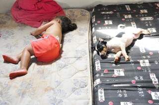 Sobre colchão no chão, criança dorme em casa invadida no final de semana em Dourados (Foto: Eliel Oliveira)